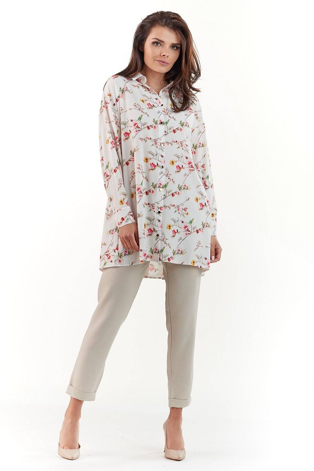 Elegant Long Sleeve Shirt with Charming Crease. A model confidently poses in a stunning floral patterned shirt, accentuated by soft pastel colours, complementing tailored trousers and elegant heels.