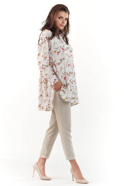 Elegant Long Sleeve Shirt with Charming Crease. A close side view of a model in a floral patterned long sleeve shirt, capturing the luxurious design and sophisticated silhouette, perfectly styled with neutral trousers.