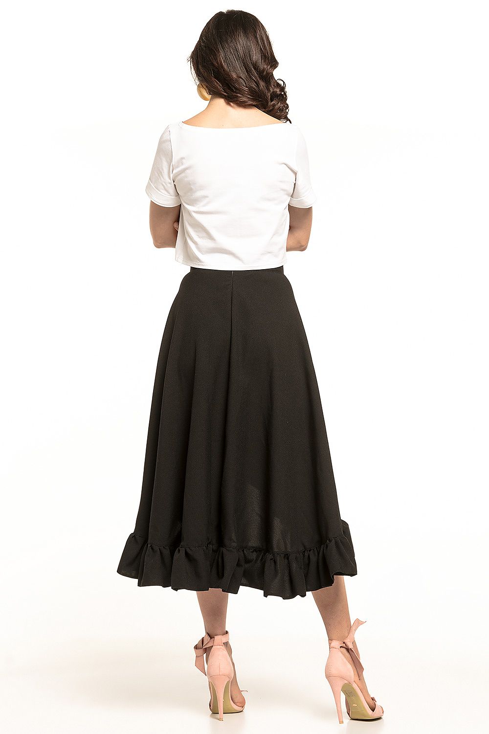 Rear view of a Tessita elegant asymmetrical midi skirt with frill detail, highlighting a model in a cropped white top paired with a flowing black skirt, ideal for a sophisticated and stylish look.