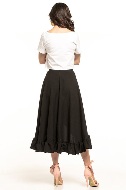 Rear view of a Tessita elegant asymmetrical midi skirt with frill detail, highlighting a model in a cropped white top paired with a flowing black skirt, ideal for a sophisticated and stylish look.