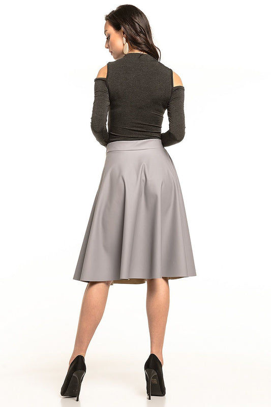 Back view of a model wearing a chic flared midi skirt in eco-leather by Tessita, highlighting the luxurious texture and design.