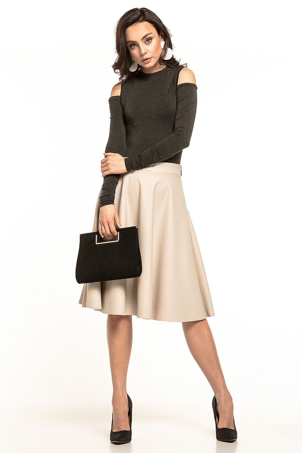 Elegant model holding a stylish black clutch, dressed in a flared eco-leather midi skirt by Tessita, perfect for upscale gatherings.