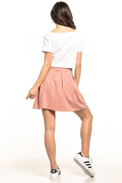 Elegant Tessita women's mini pleated skirt in soft pink, styled for a casual summer look, featuring a concealed zip at the back.