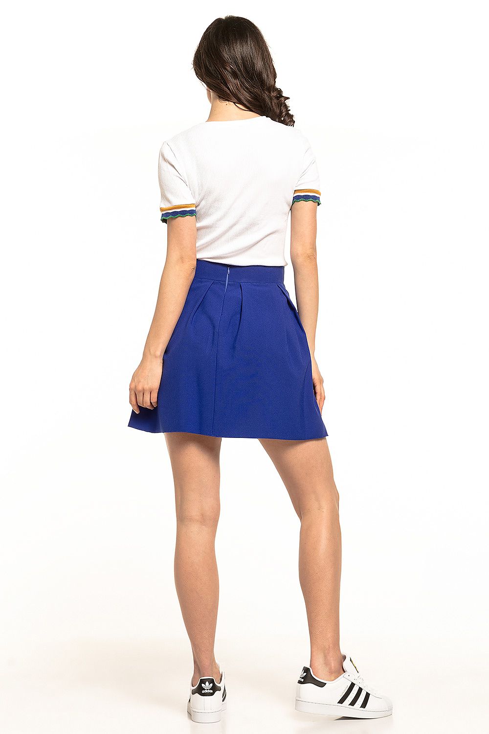 Back view of Tessita Women's Mini Pleated Skirt in blue, elegantly paired with a white top, exemplifying casual sophistication.