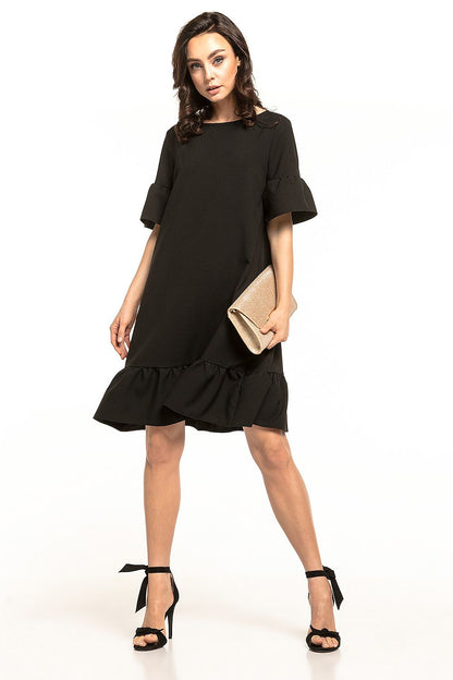 Elegant black mini dress by Tessita featuring a stylish bow neckline and a delicate frill hem, perfect for summer outings.