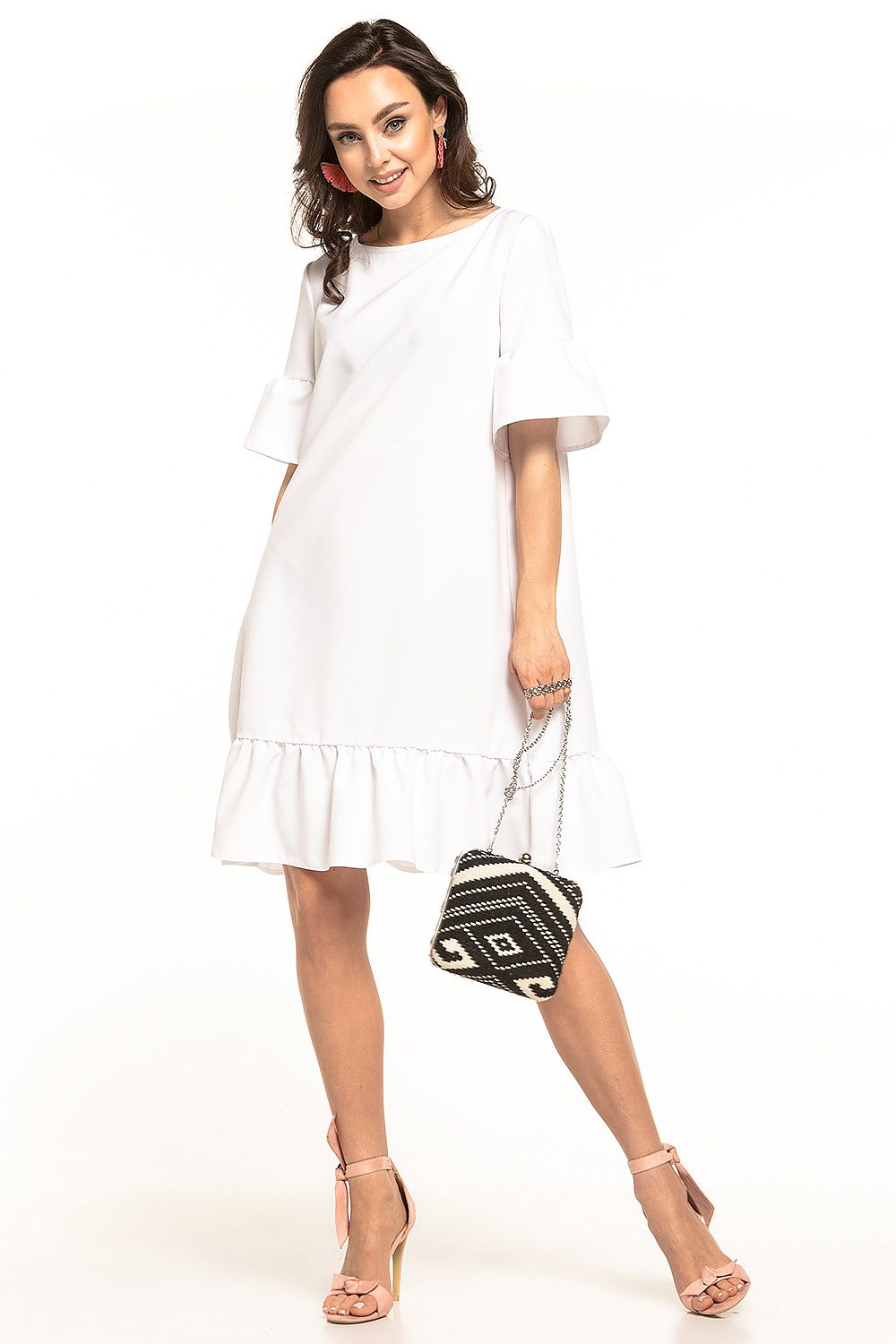 Chic white mini dress by Tessita with a bow neckline and frill hem, exemplifying luxury summer fashion paired with stylish accessories.