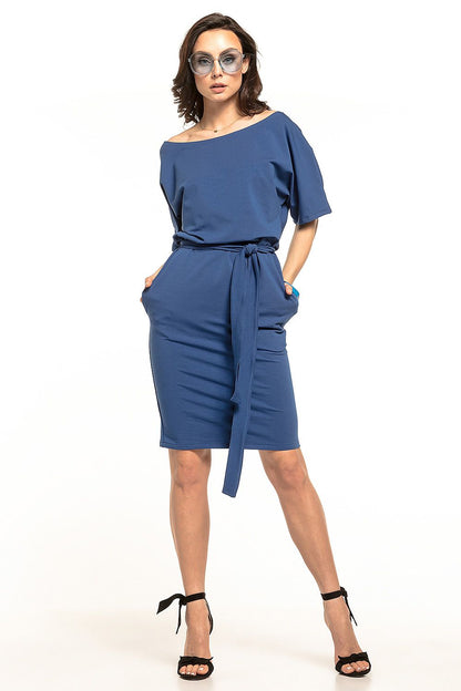 Chic model in a soft blue midi dress with kimono sleeves and a waist belt by Tessita, posing confidently with a relaxed expression.