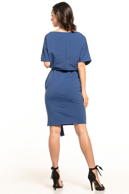 Fashionable woman featuring a back view of a sophisticated blue midi dress by Tessita, highlighting the kimono sleeves and tailored fit.
