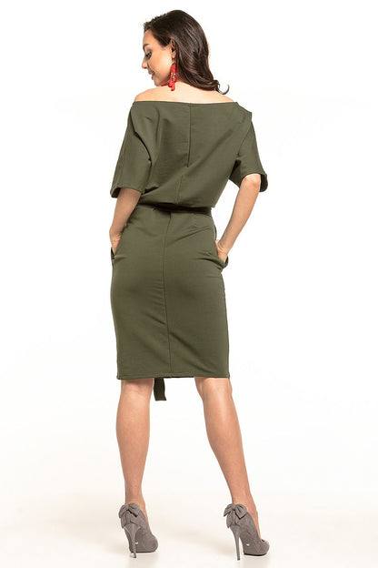 Glamorous woman showcasing the back of a refined olive green midi dress with kimono sleeves and a waist tie by Tessita, styled for a chic look.