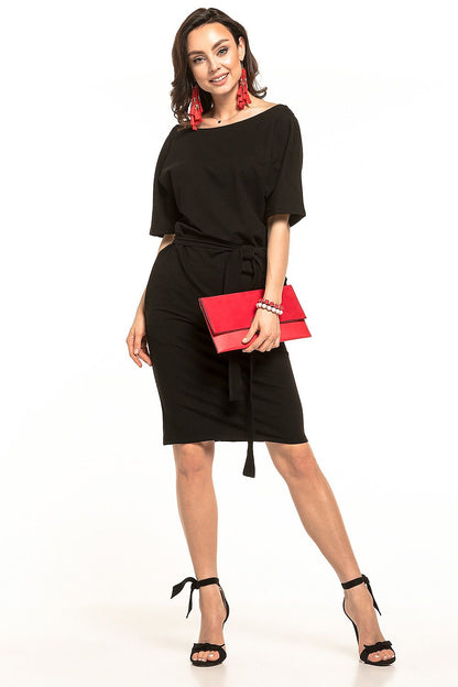 Chic black midi dress by Tessita featuring kimono sleeves and a decorative belt, paired with elegant black heels and a red clutch purse.