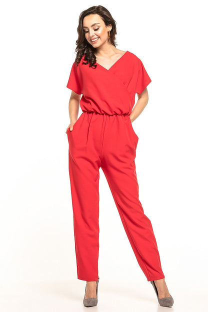 Stunning Tessita jumpsuit in vibrant red with short sleeves and gathered waist, portrayed on a joyful model, radiating elegance and confidence.