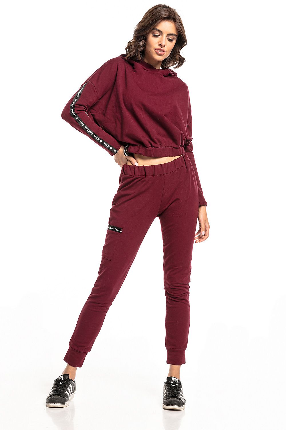 Model showcasing Luxury Tessita straight-cut tracksuit trousers in burgundy, featuring a drawstring waist and stylish side pockets. Perfect combination of comfort and elegance.