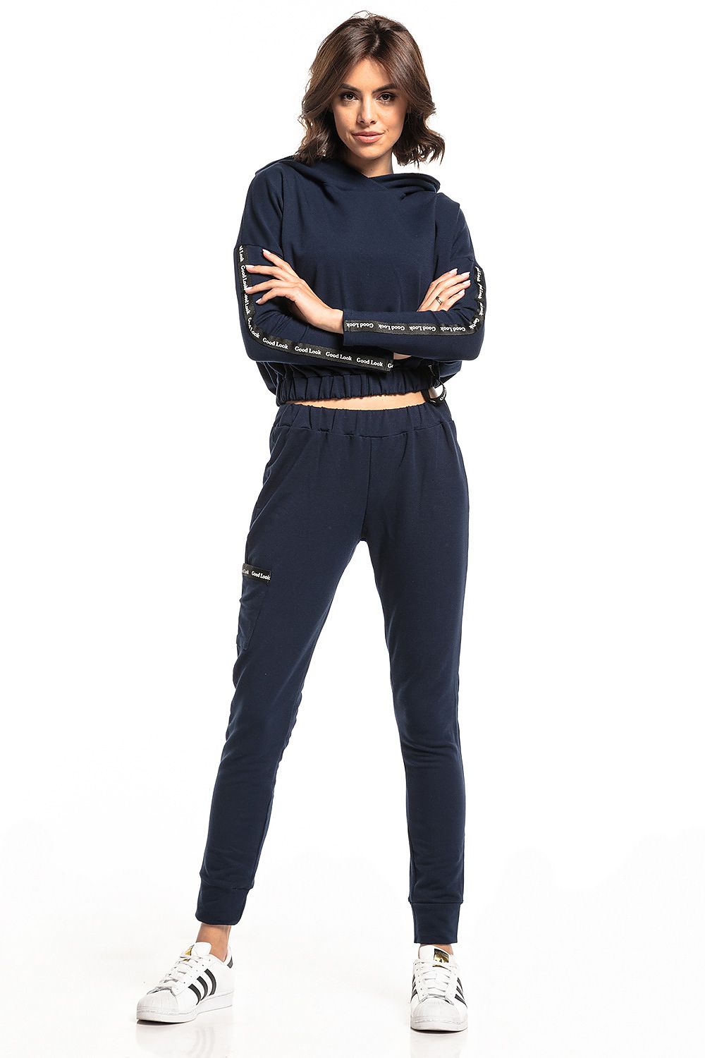 Elegant model in navy blue Tessita tracksuit featuring straight-cut trousers and cropped top, adding a touch of luxury to sporty fashion.