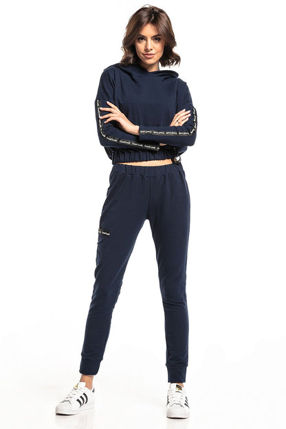 Elegant model in navy blue Tessita tracksuit featuring straight-cut trousers and cropped top, adding a touch of luxury to sporty fashion.