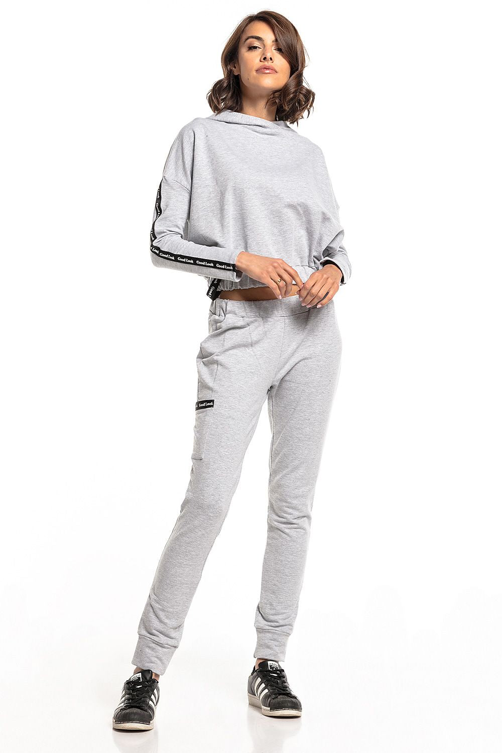 Front view of a model in luxury Tessita straight-cut tracksuit trousers, featuring a chic cropped top and drawstring waist, highlighted in a modern light grey shade.