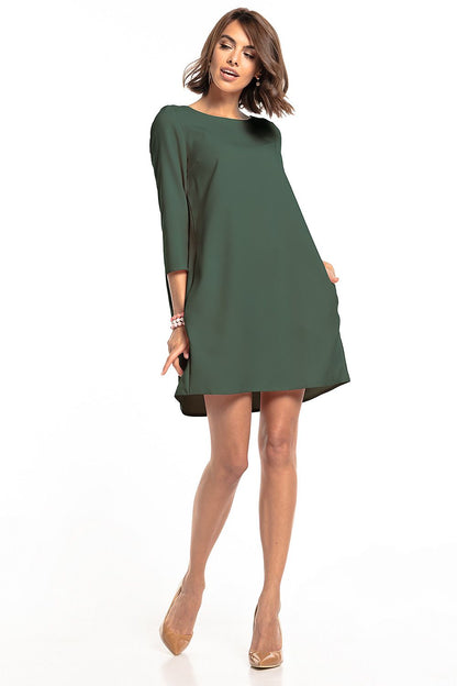 Elegant green pleated daydress with pockets by Tessita, showcasing a modern silhouette and sophisticated style, perfect for various occasions.