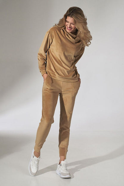 Woman in the Figl Velour Tracksuit Trousers with Tapered Legs and Drawstring Waist in a beautiful caramel shade, radiating style and comfort.