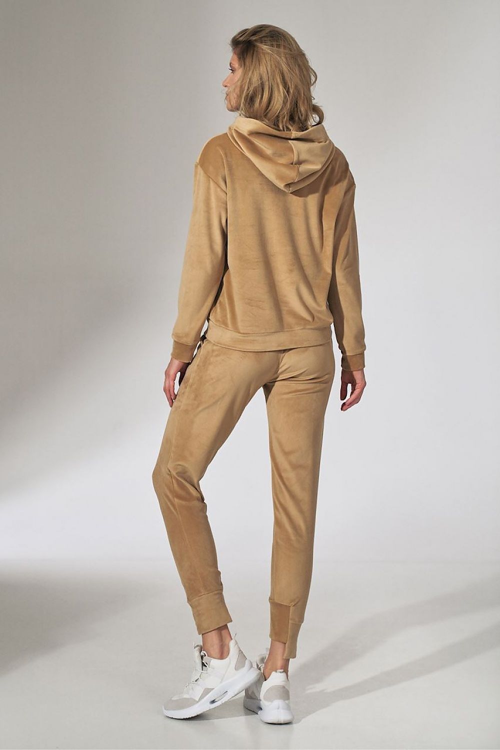 Back view of a woman in the Figl Velour Tracksuit Trousers with Tapered Legs and Drawstring Waist in caramel, emphasizing the sleek lines and elegant fabric.