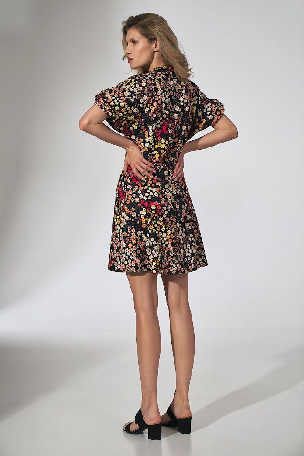 Back view of a Floral Kimono Mini Dress by Figl, illustrating a model wearing the dress, capturing the stylish silhouette and floral details against a minimalist backdrop.