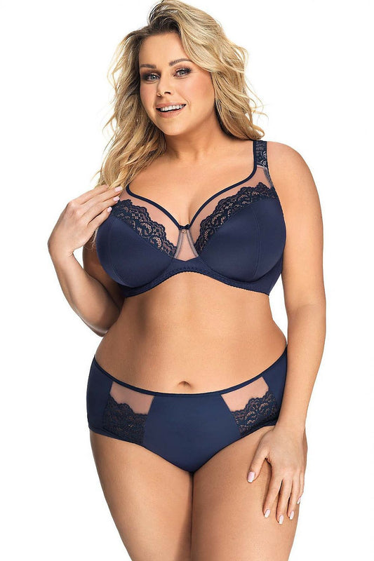Beautiful plus-size model showcasing elegant navy blue panties with lace inserts by Gorsenia Lingerie, designed for shapely hips, in a luxurious setting.