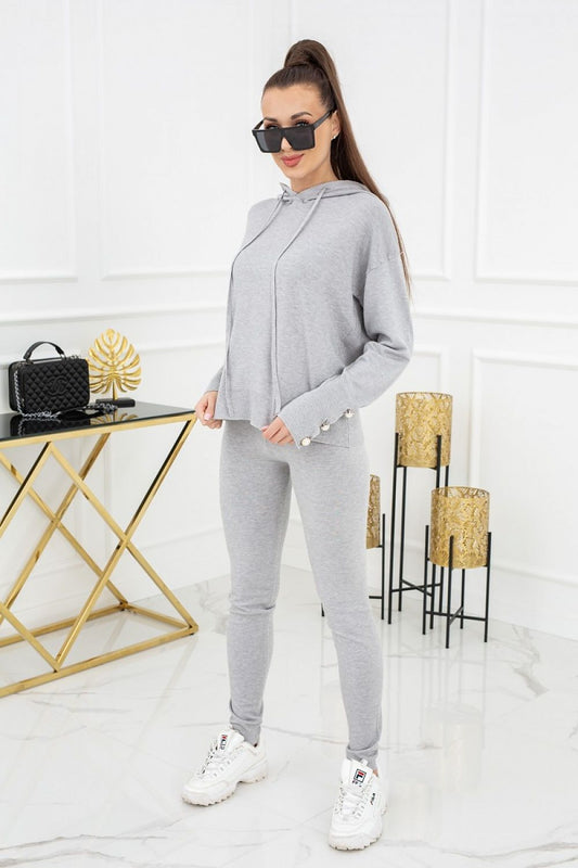 Vittoria Ventini Kim Peral Buttons Two-Piece Leggings Set - Elegant Comfort. A model showcasing the stylish grey set with decorative buttons, paired with trendy accessories.