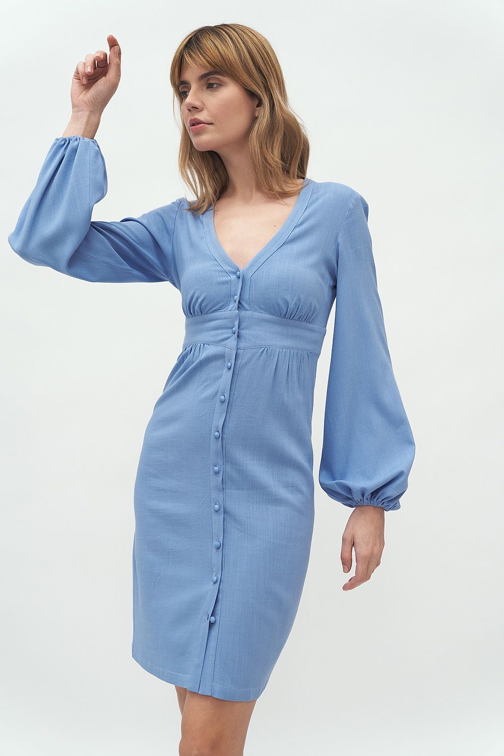 A model showcasing the Elegant Nife Daydress with puffed sleeves, featuring a waist-emphasizing cut, perfect for business attire, in a soft blue hue. Ideal for sophisticated elegance.