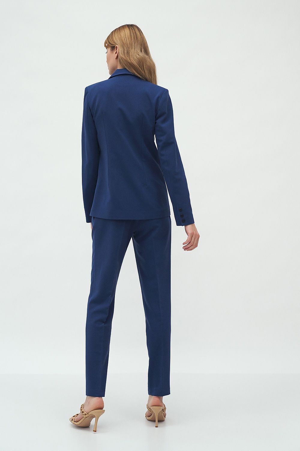 Sophisticated rear view of the elegant slim-fit Nife jacket featuring one-button fastening and waist-emphasizing design, worn by a model in a modern ambiance.