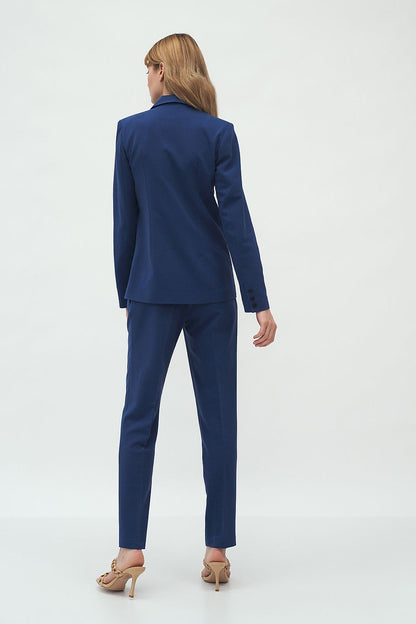 Sophisticated rear view of the elegant slim-fit Nife jacket featuring one-button fastening and waist-emphasizing design, worn by a model in a modern ambiance.