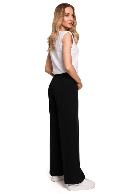 Model displaying the back profile of Elegant Wide Leg Trousers with Pleats and Elastic Waistband by Moe in black, highlighting the modern elegance and elastic comfort.