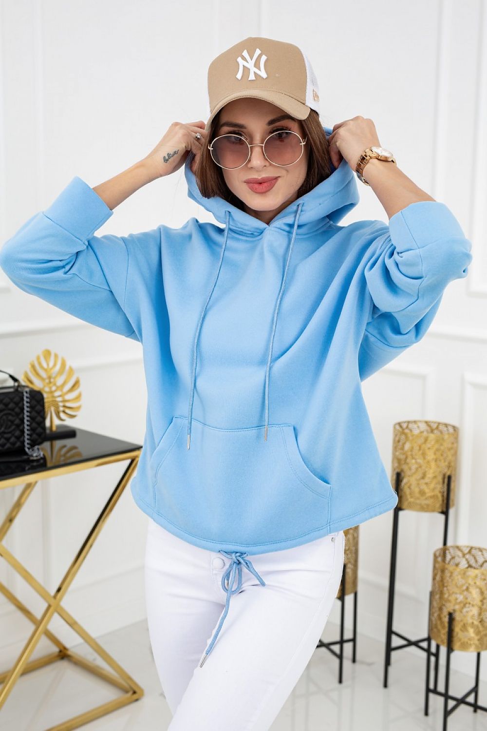 Vittoria Ventini Pastel Hooded Sweatshirt with Double Pockets, featuring a model wearing a light blue hoodie, elegantly styled with white pants and a cap for a sophisticated spring appeal.