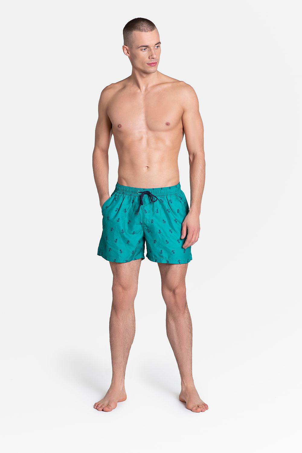 Henderson Men's Quick-Drying Swim Trunks with Navy Pattern, Pockets & Lining displayed on a model, showcasing vibrant turquoise colour and stylish design for beach and casual wear.