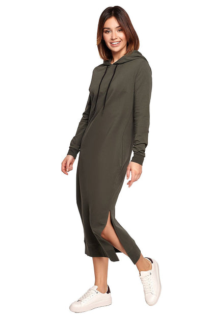 Chic model showcasing the BeWear Cotton Spandex Daydress in olive green, complete with a hood, side slits, and ribbed trims for a timeless look.