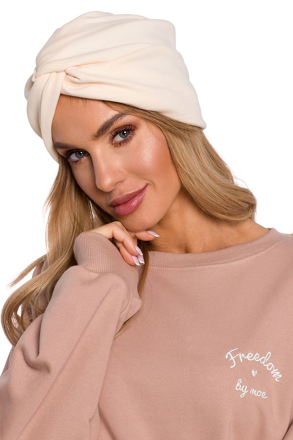 Stylish woman in a luxury lightweight knitted turban cap in soft cream, radiating sophistication and comfort from Moe.