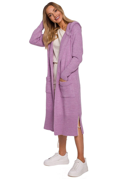 Charming model wearing a luxurious long cardigan by Moe in a vibrant lavender hue, featuring a fitted hood and practical pockets, complemented by sporty white shoes.