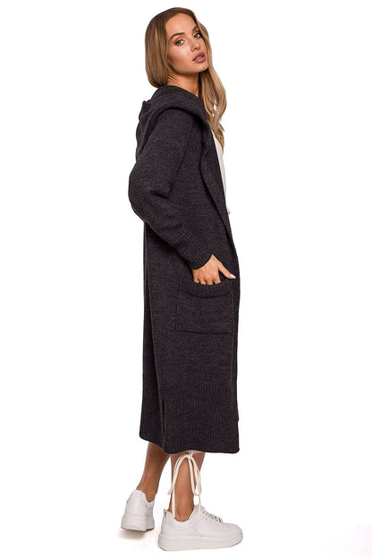 Side view of the luxurious long cardigan with fitted hood, pockets, and side slits by Moe, highlighting its stylish design and texture on a model.