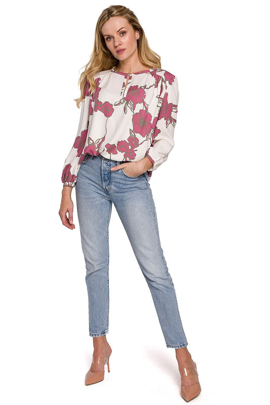 A sophisticated model poses in a Luxury Floral Viscose Blouse by Makover, styled with jeans, highlighting the blouse's flexible design suitable for various occasions.