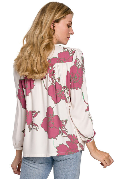 A model presents the back view of a Luxury Floral Viscose Blouse by Makover, featuring a delicate floral print, illustrating its elegant cut ideal for multiple styling options.