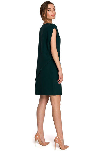 Stylove Daydress styled from the back, displaying its sophisticated asymmetrical cut and luxurious fabric in a stunning green shade, ideal for stylish events.