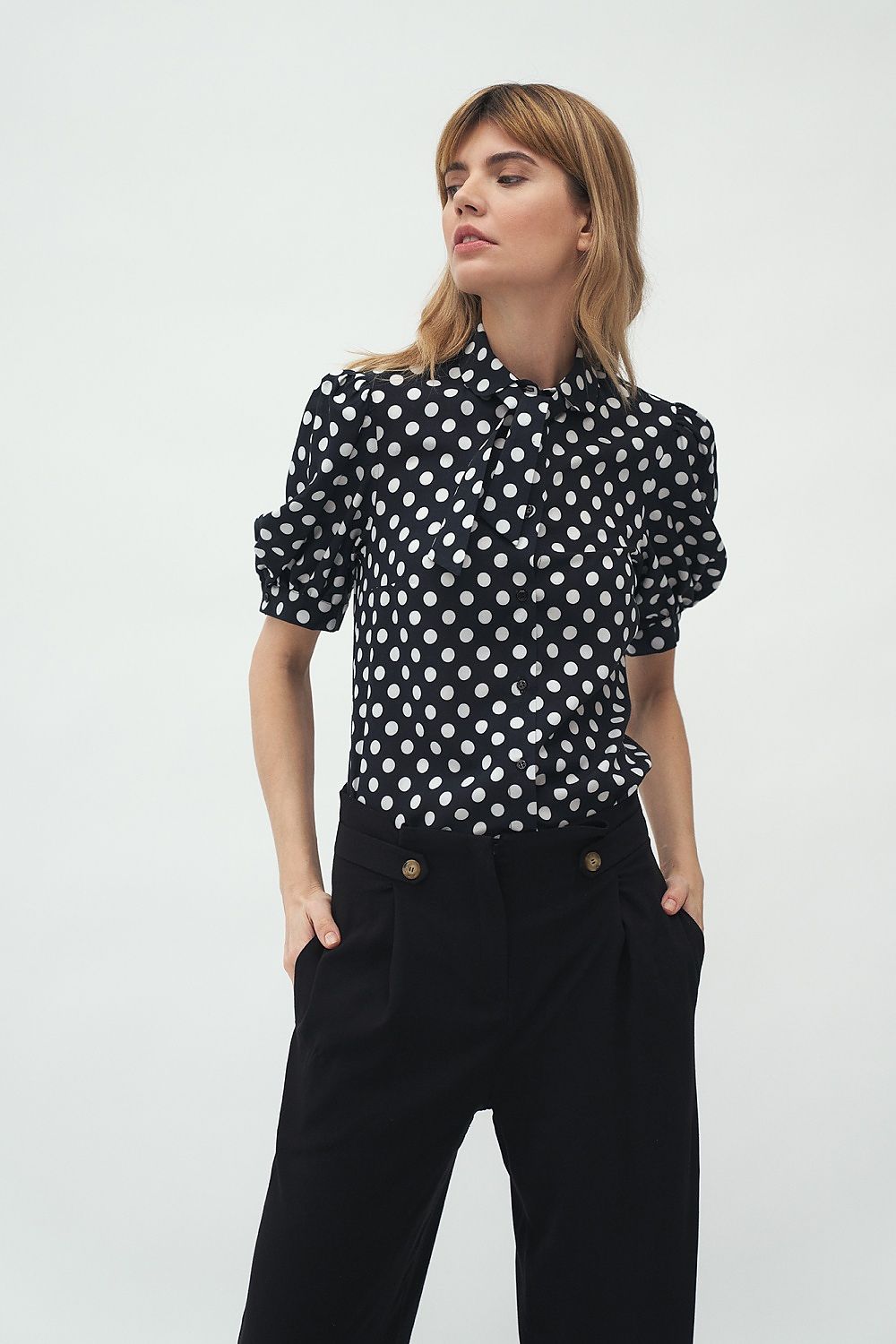 Elegant short sleeve shirt by Nife, featuring a stylish black and white polka dot design, perfect for a sophisticated casual look. The shirt showcases delicate details with a collar and a feminine silhouette, ideal for hot summer days.