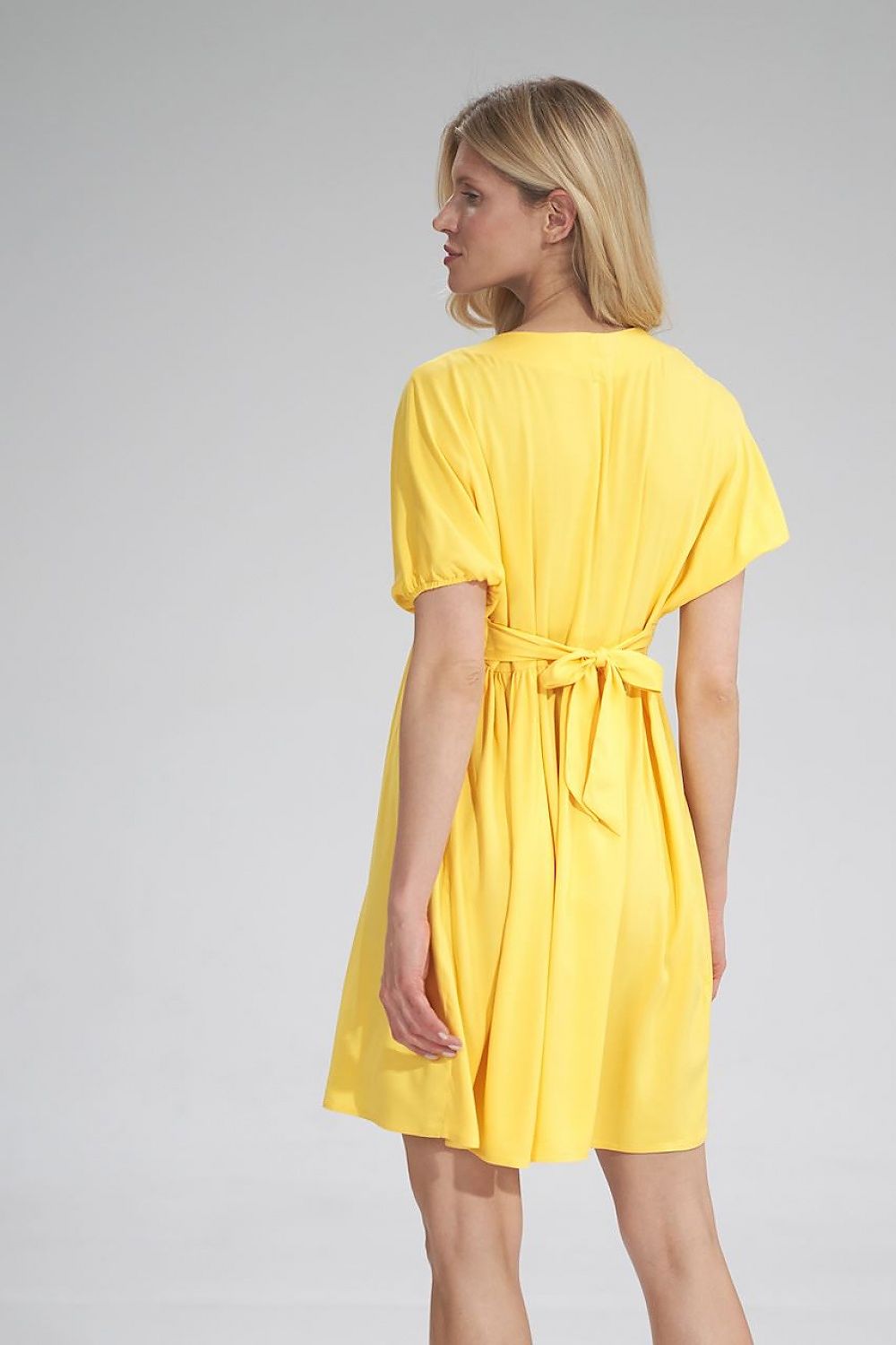 Rear view of the stunning yellow Daydress Figl, emphasising the seamless fabric belt detail, perfect for accentuating the waist.