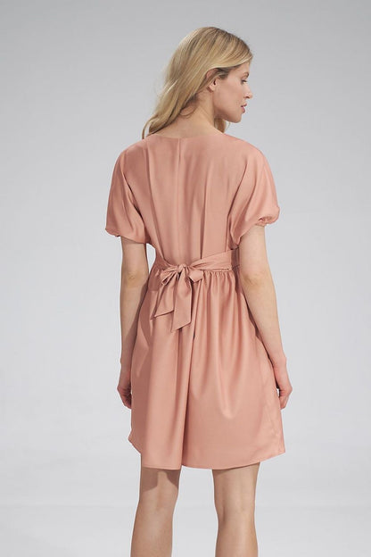 Back view of the elegant peach Daydress Figl, with a fabric belt accentuating the waist, ideal for a feminine and graceful appearance.