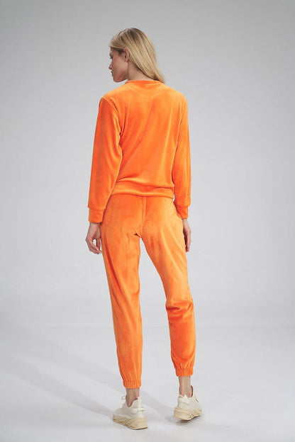 Chic model in Figl Tracksuit trousers in rich orange velour, displaying a fashionable back view, ideal for a luxurious athleisure look.