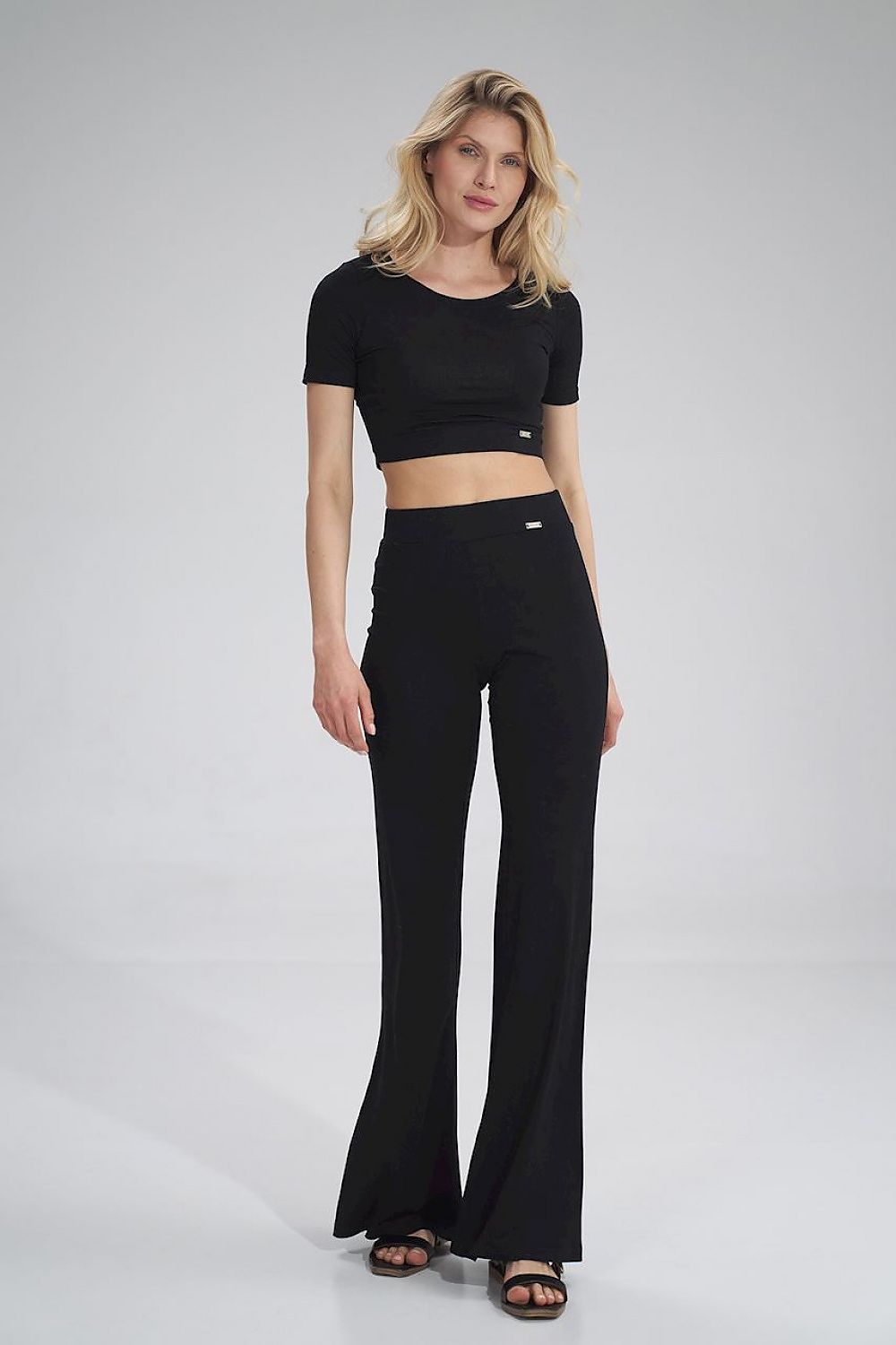 Sophisticated look featuring the Figl crop style blouse paired with stylish black flared trousers, highlighted on a poised female model.