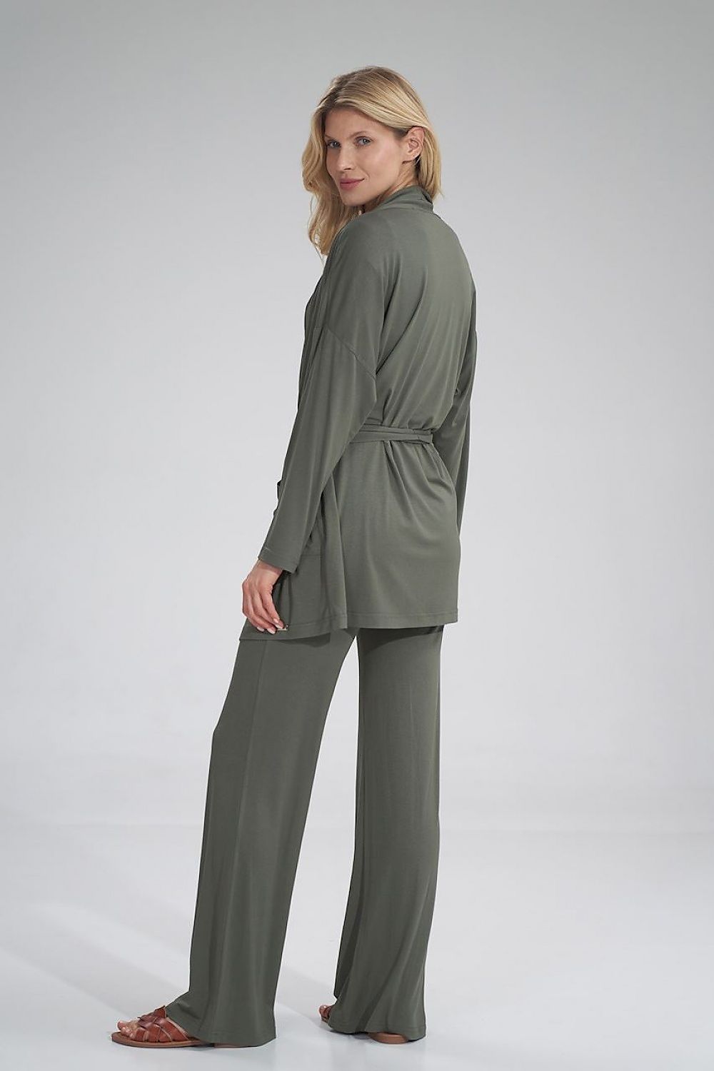 Elegant poster showcasing a woman wearing a loose-fitting, unbuttoned Figl sweatshirt, tied with a belt, featuring large front pockets. The garment is styled in a chic olive green shade, presenting a sophisticated look suitable for casual and fashionable occasions.