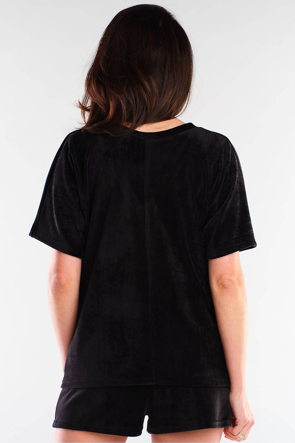 Back view of a luxurious black velour outfit by awama, combining plush shorts and a stylish top for an effortlessly elegant look.