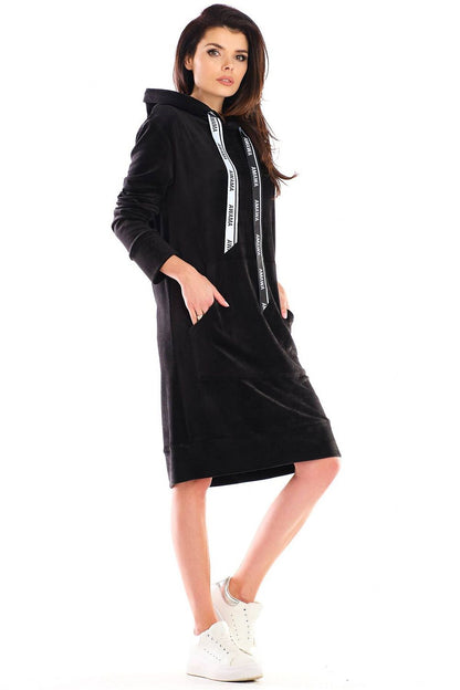 Model showcasing a glamorous velour midi daydress by Awama, emphasising its practical design with a hood and spacious pockets, paired with fashionable sneakers.
