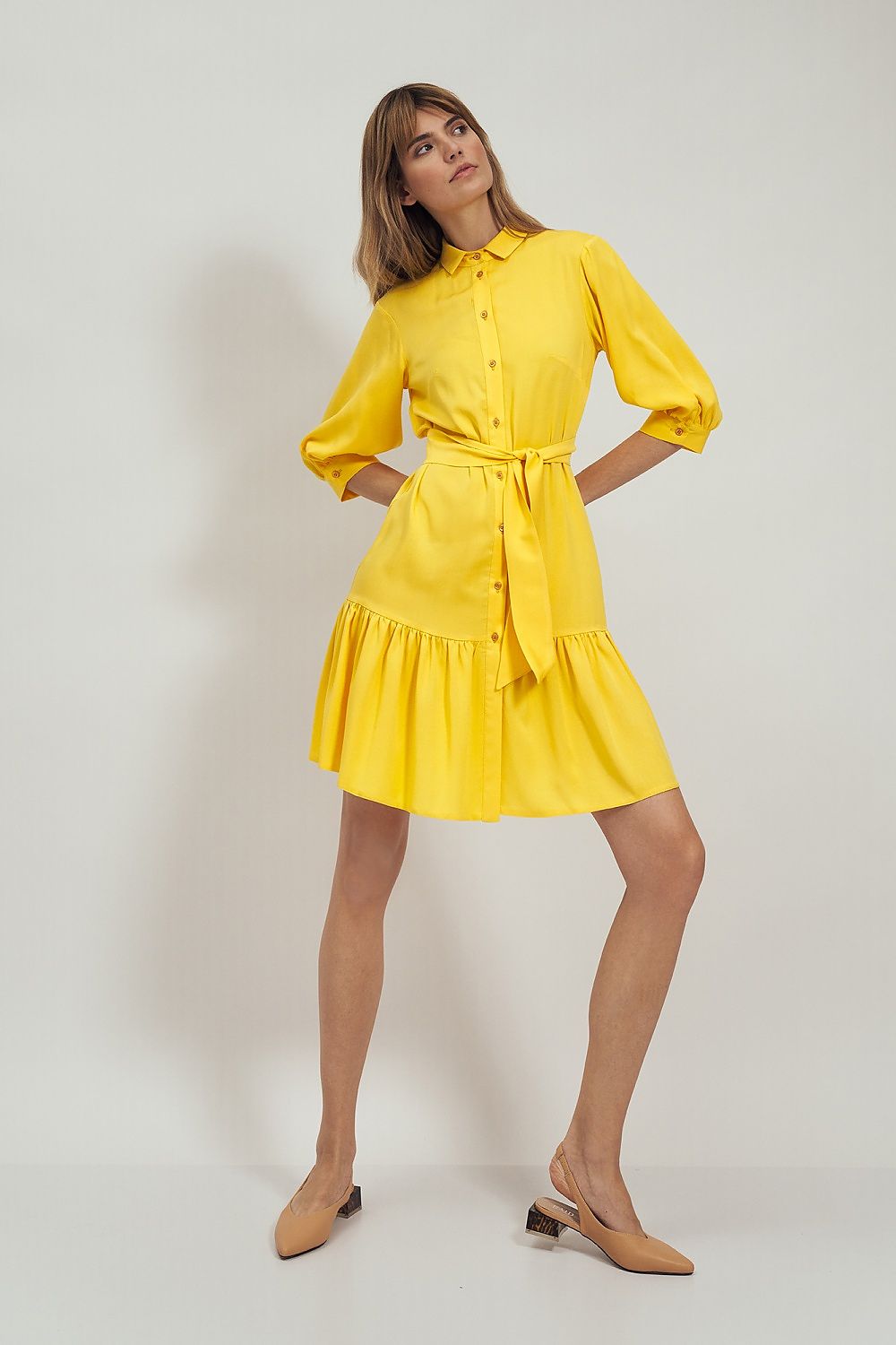 Side view of the Nife Daydress Nife, featuring a vibrant yellow design with a belted waist, flared hem, and stylish puff sleeves, exemplifying luxury fashion.