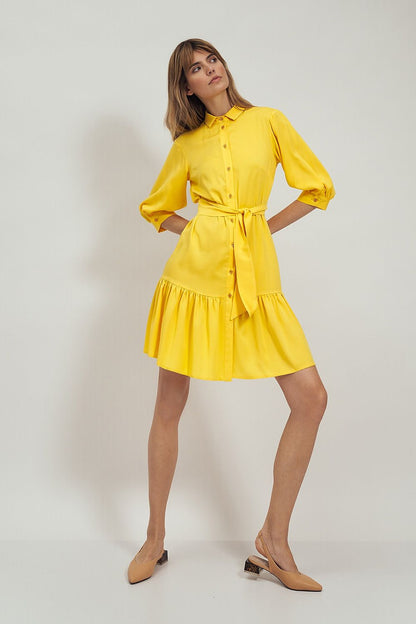 Side view of the Nife Daydress Nife, featuring a vibrant yellow design with a belted waist, flared hem, and stylish puff sleeves, exemplifying luxury fashion.