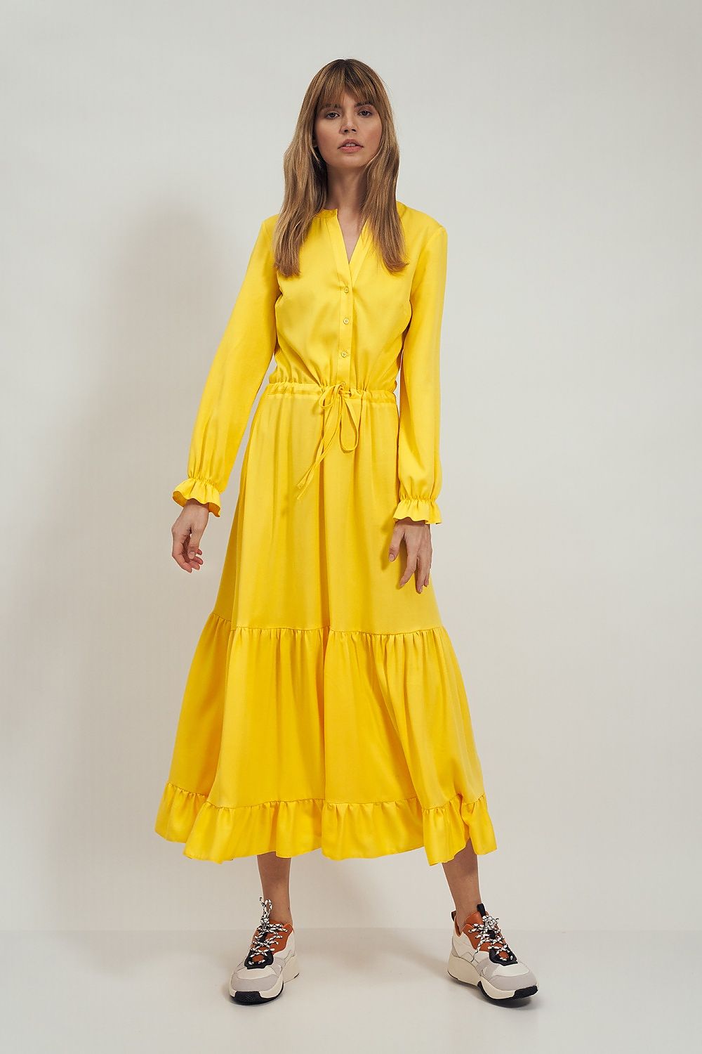 Elegantly styled Daydress Nife in vibrant yellow, featuring a tie detail to accentuate the waist and delicate frill trims on the sleeves and hem, perfect for a luxurious casual outfit.