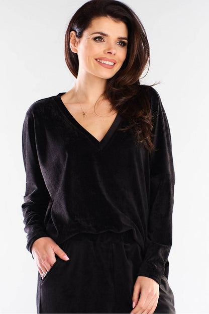 Sophisticated Awama women's black loose-fit sweatshirt with a deep V-neckline, perfect for versatile urban fashion paired with sleek trousers.